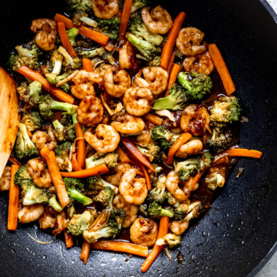 stir fry with broccoli and carrots in large black wok.