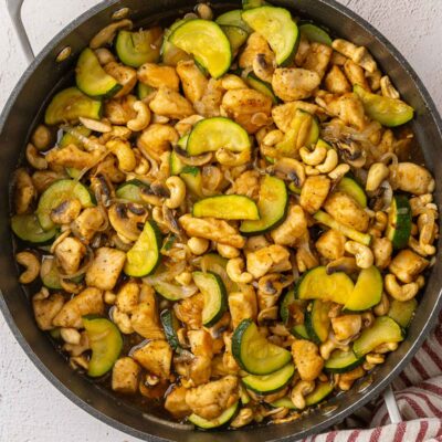 Cooked cashew chicken stir fry in black pan.