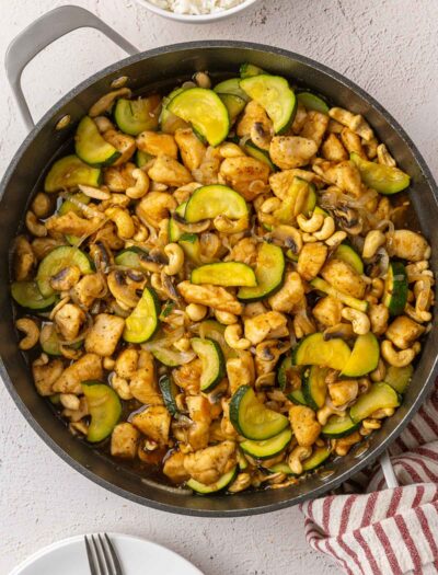 Cooked cashew chicken stir fry in black pan.