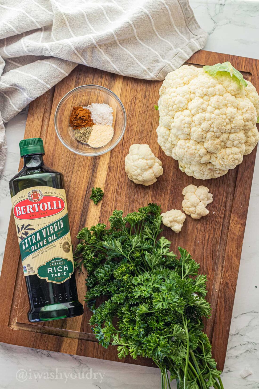 Ingredients for air fryer cauliflower on wood cutting board. 