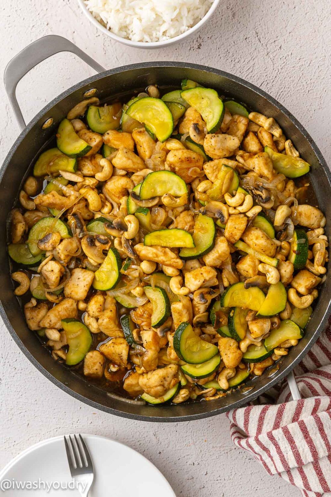 Cooked cashew chicken in metal frying pan.