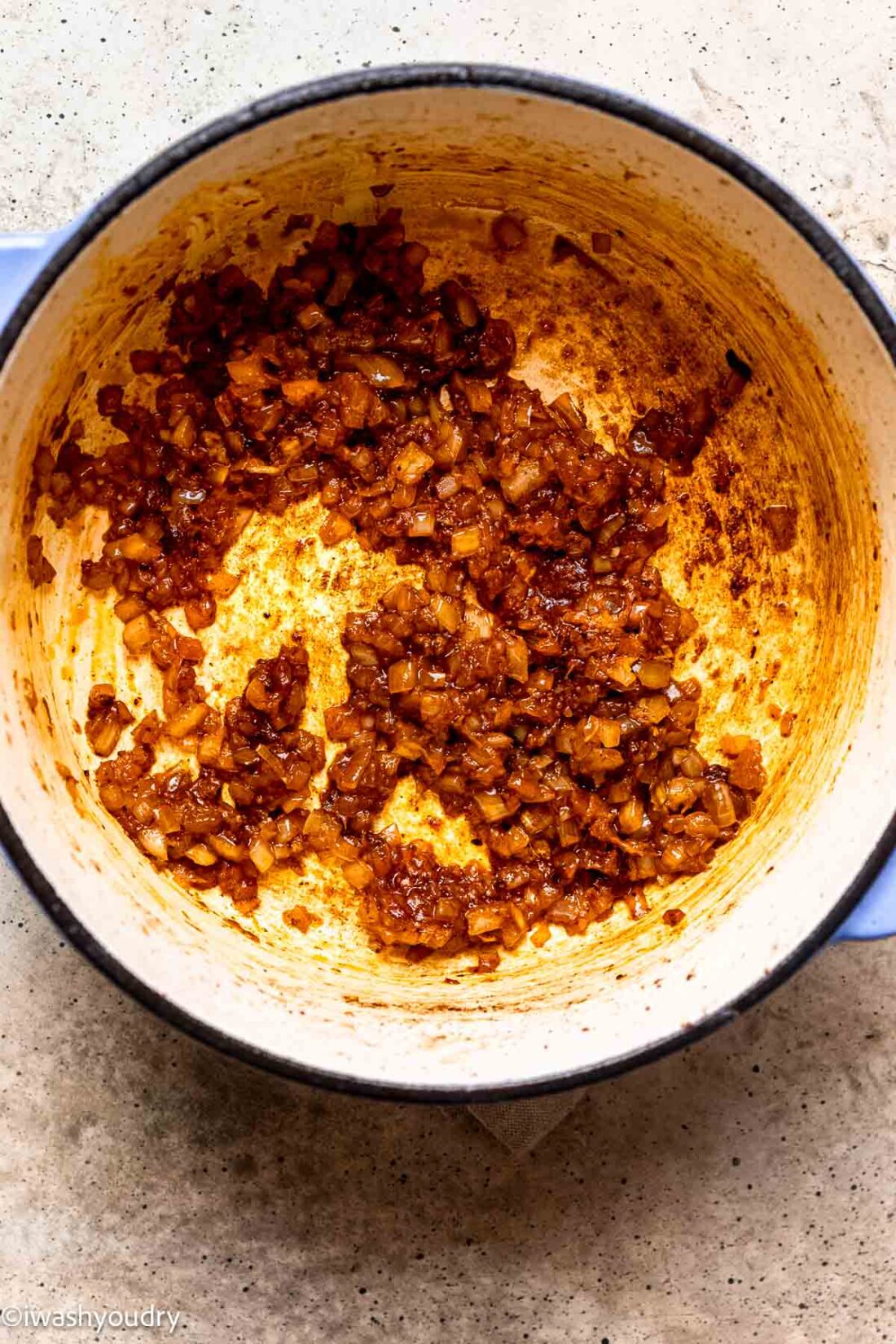 Cooked onions and curry paste in ceramic pot. 