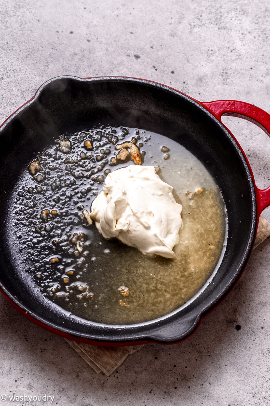 Onion chive cream cheese in skillet with white wine. 