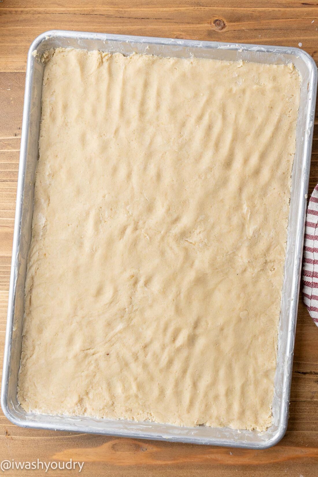 Raw crust for pumpkin pie bars in metal pan. 