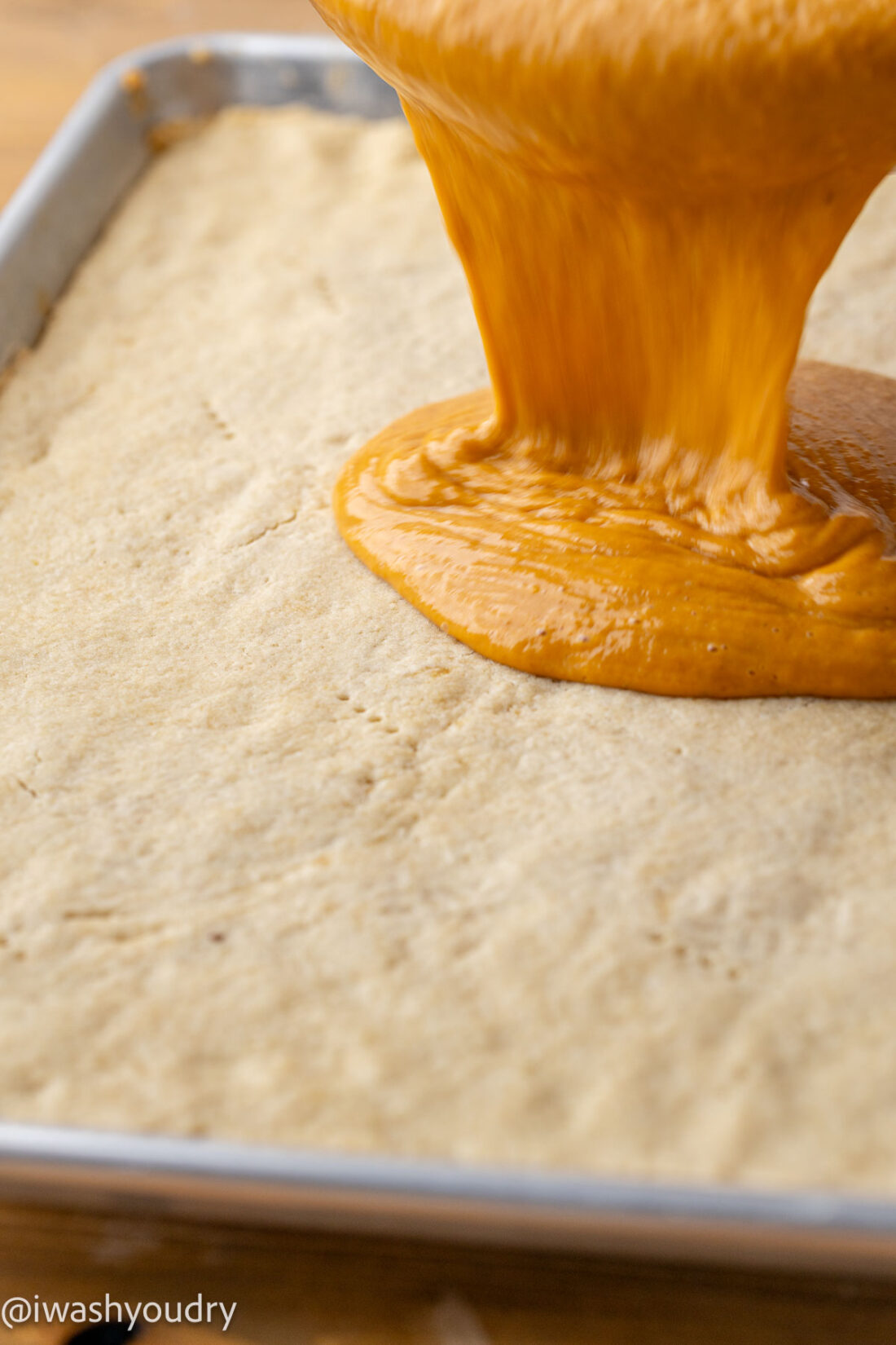 Pouring pumpkin filling onto baked crust. 