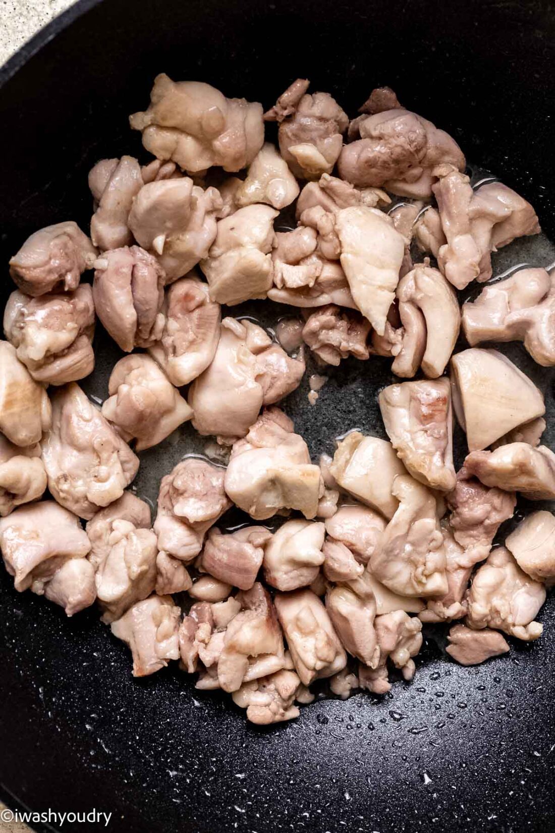 Cooking raw chicken in wok. 