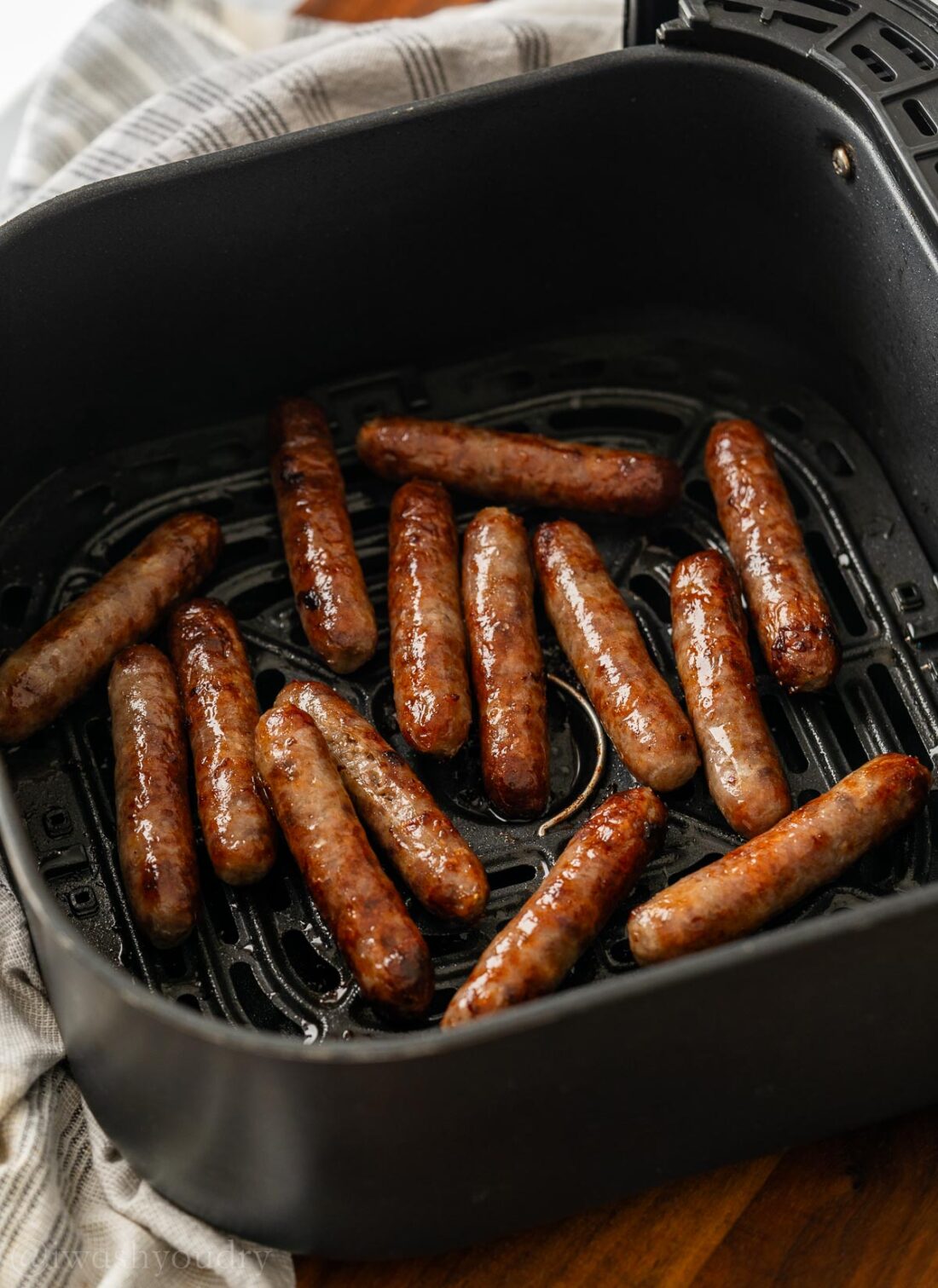 Cooked air fryer sausage in basket of air fryer. 