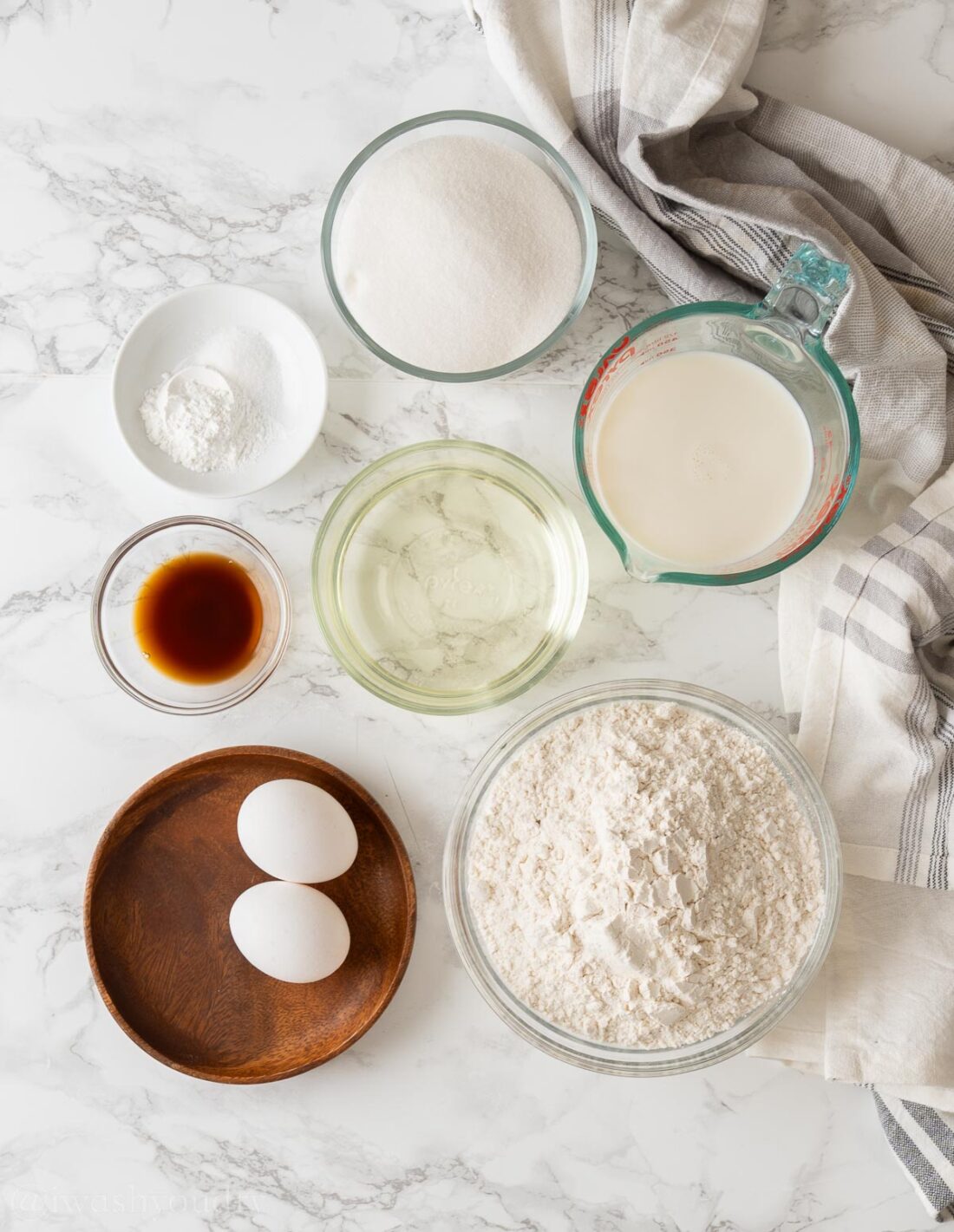 Ingredients for classic coffee cake in glass bowls on marble countertop. 