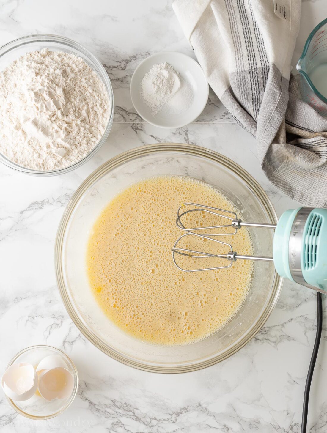 Wet ingredients in glass bowl with whisk.