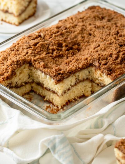 Baked and sliced classic coffee cake in glass pan.