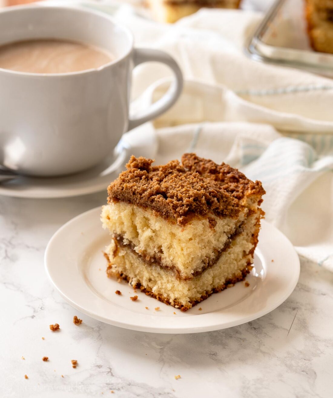 Slice of baked coffee cake on white plate. 