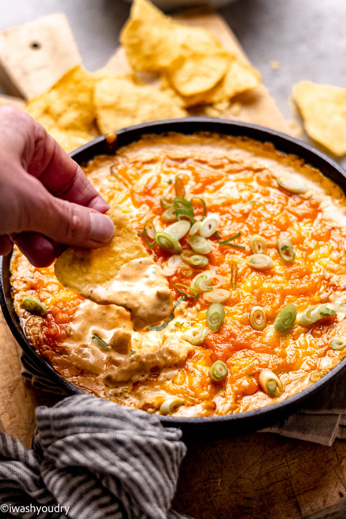 Chip dipping into baked buffalo chicken dip. 