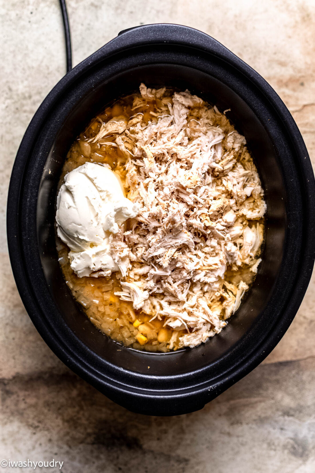 Cream cheese in slow cooker with shredded chicken and chicken chili. 