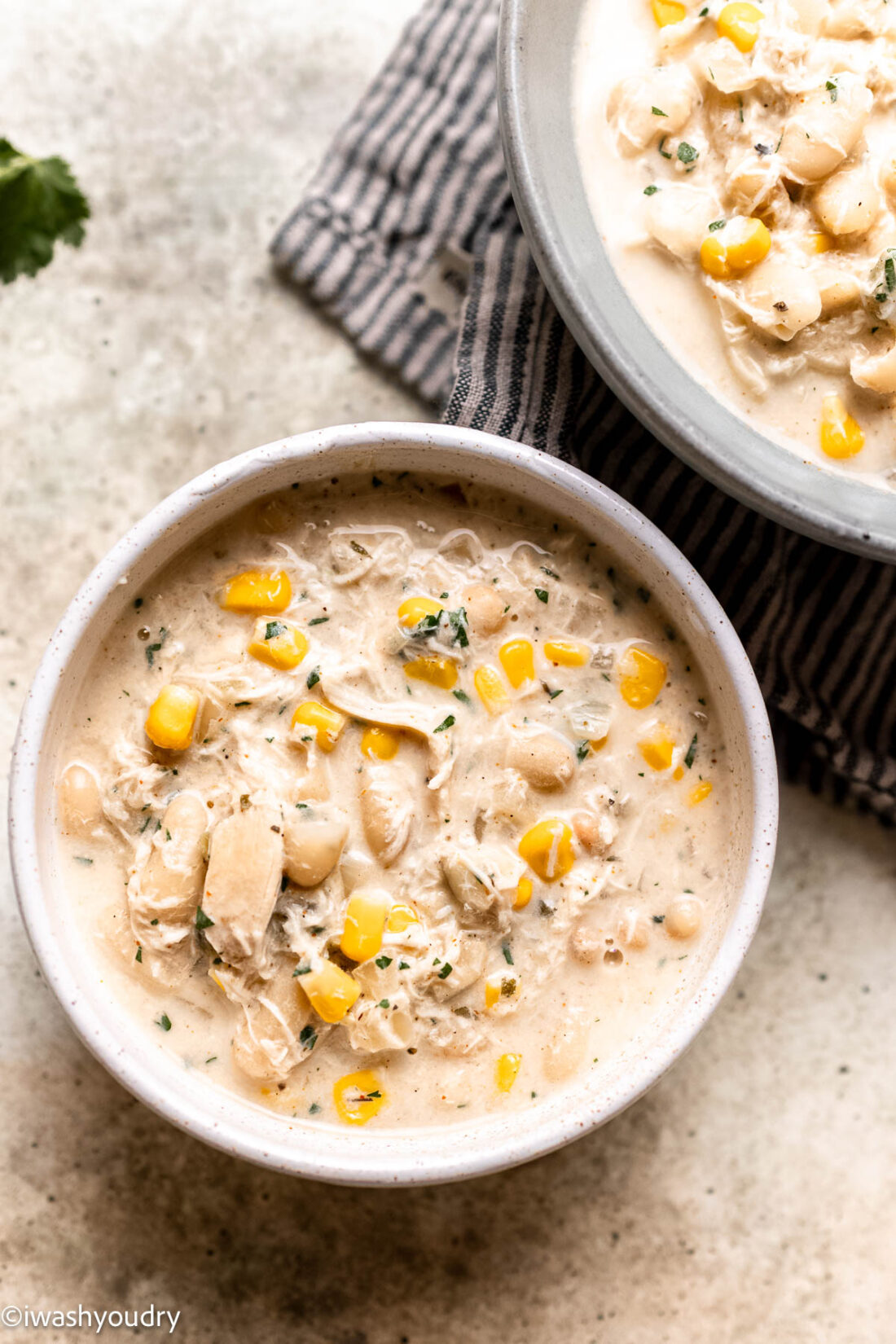 Cooked white chicken chili with cilantro in a bowl. 
