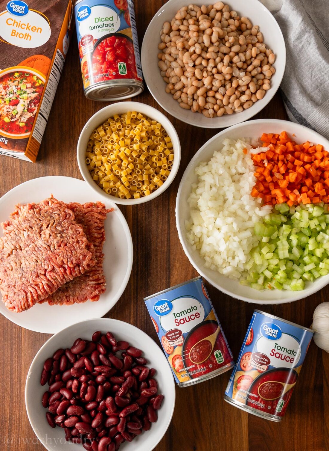 ingredients for Pasta Fagioli Soup on wooden surface with beans and pasta.