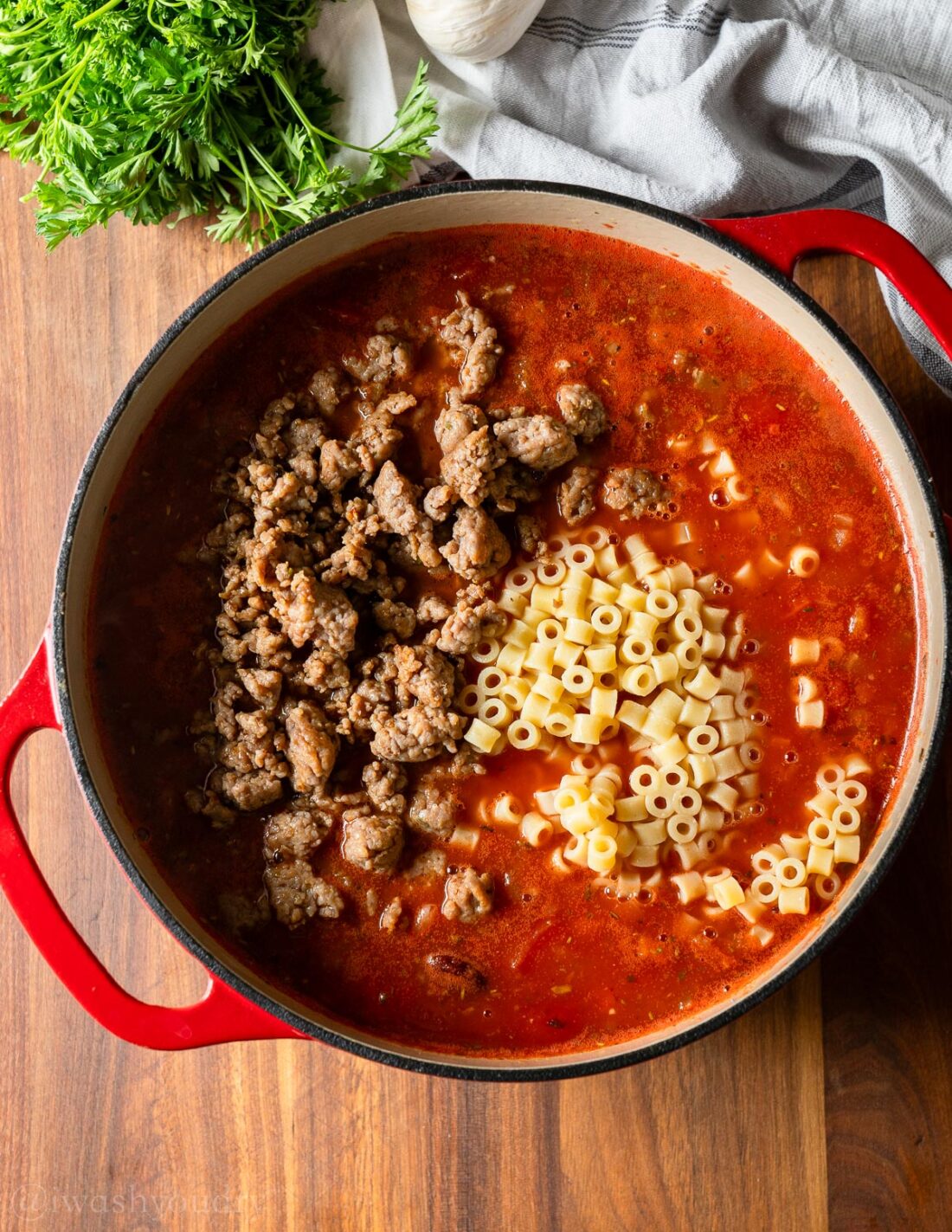 pot of italian soup with pasta and sausage with beans.