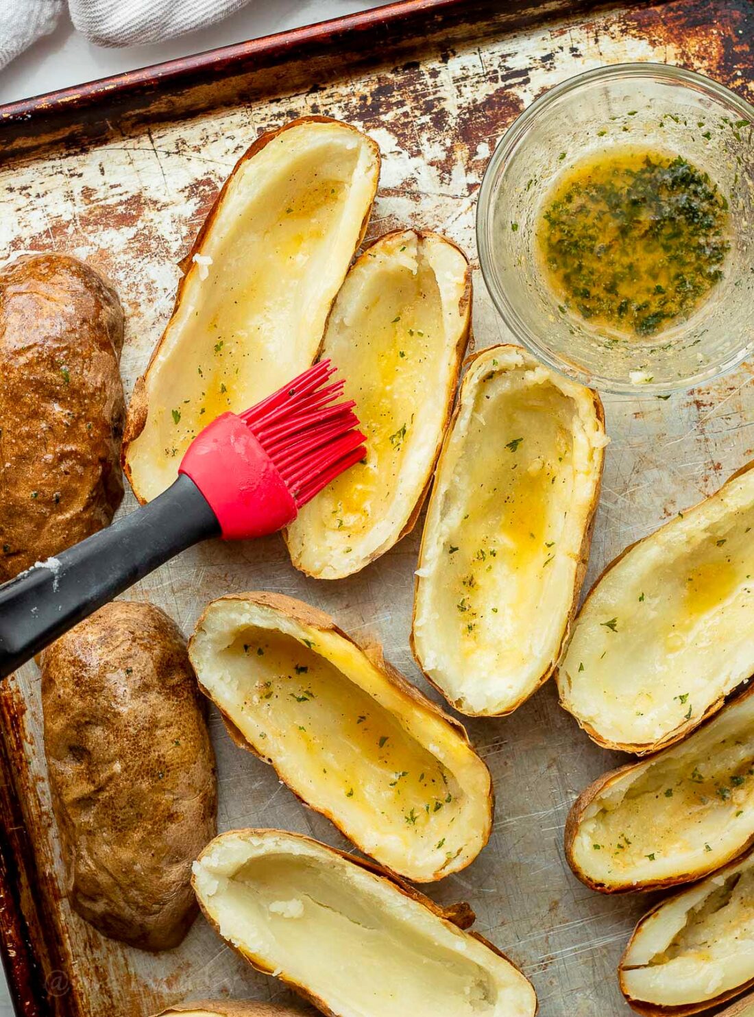 brushing hallowed out potatoes with melted butter and seasonings.