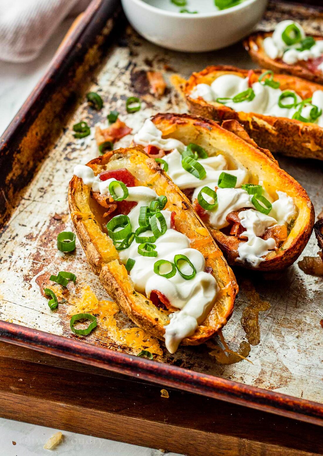 Crispy potato skins with sour cream and bacon on top.