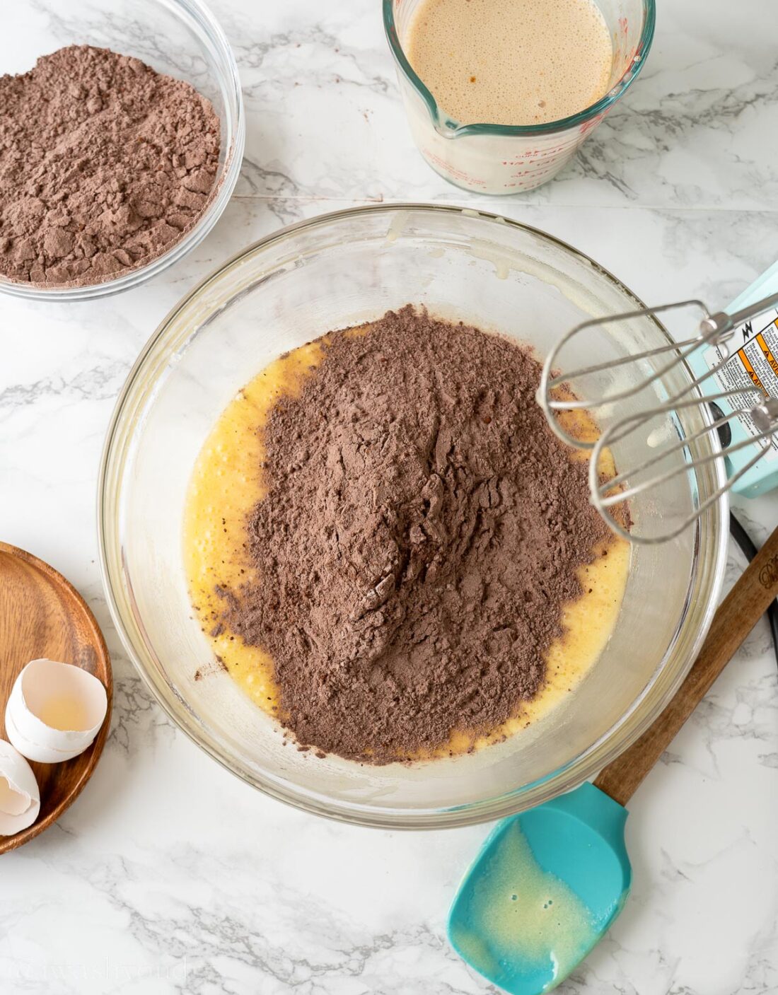 adding dry cake mix ingredients to wet ingredients with beater.