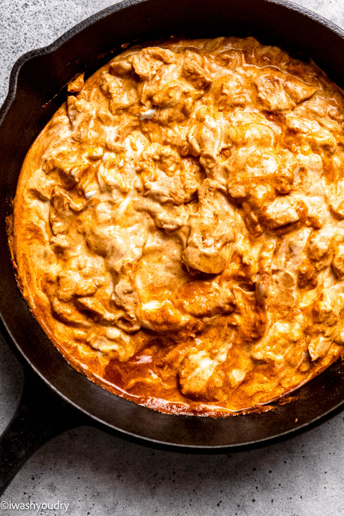 creamy buffalo chicken dip in black skillet.