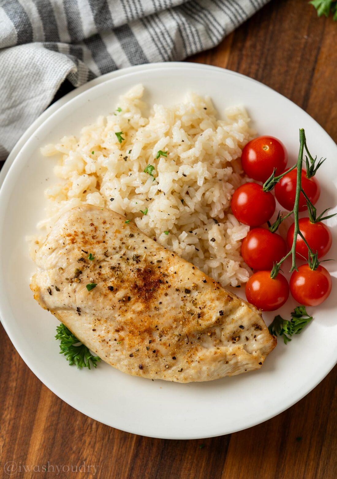 Air fryer chien on white plate with rice and tomatoes. 