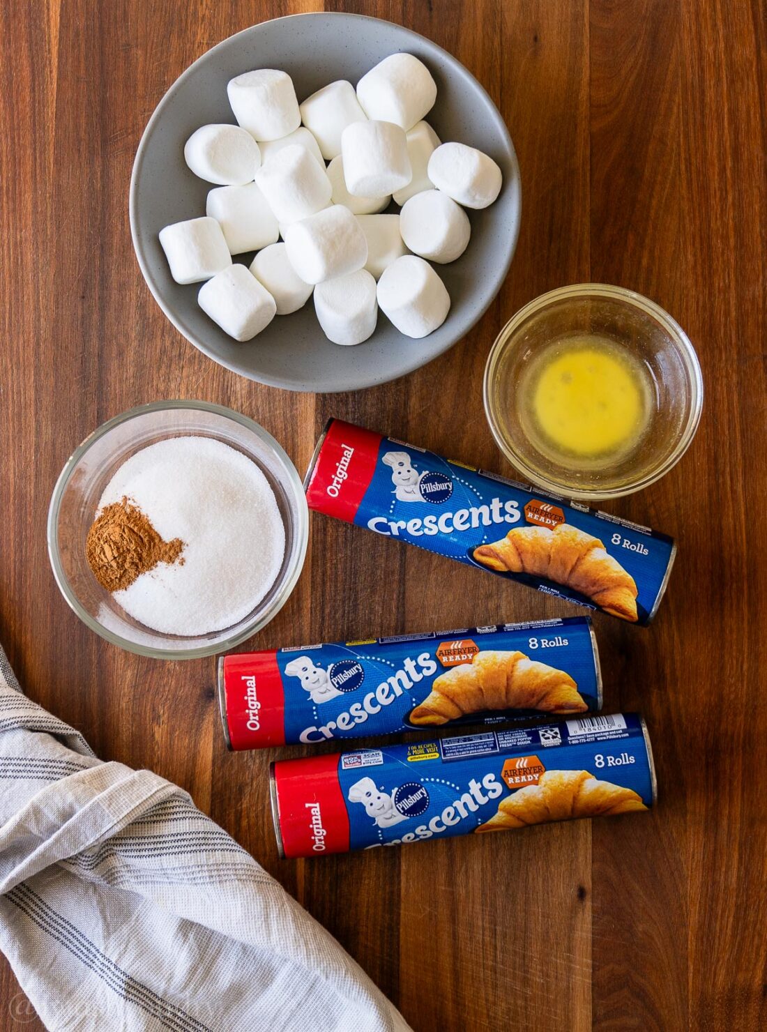 ingredients for rolls on table with butter, marshmallows and crescent rolls.