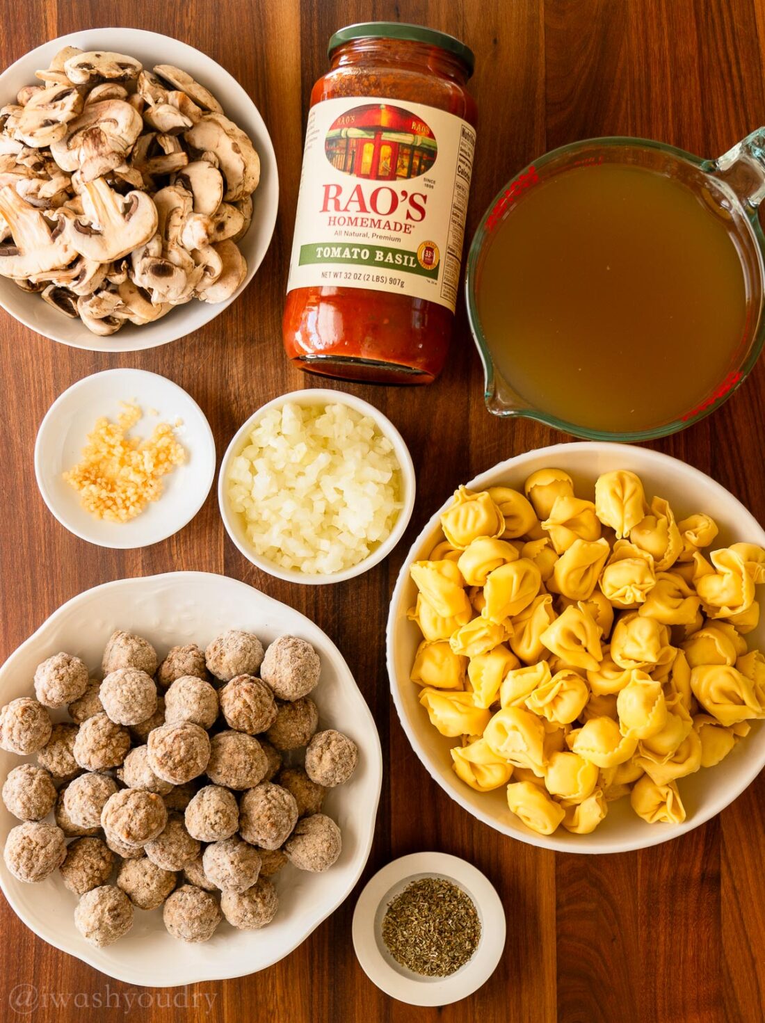 Ingredients for tortellini meatball soup on wood cutting board.