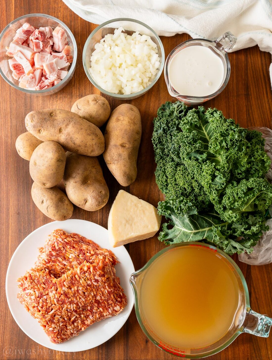 Ingredients for zuppa toscana soup on wood cutting board.