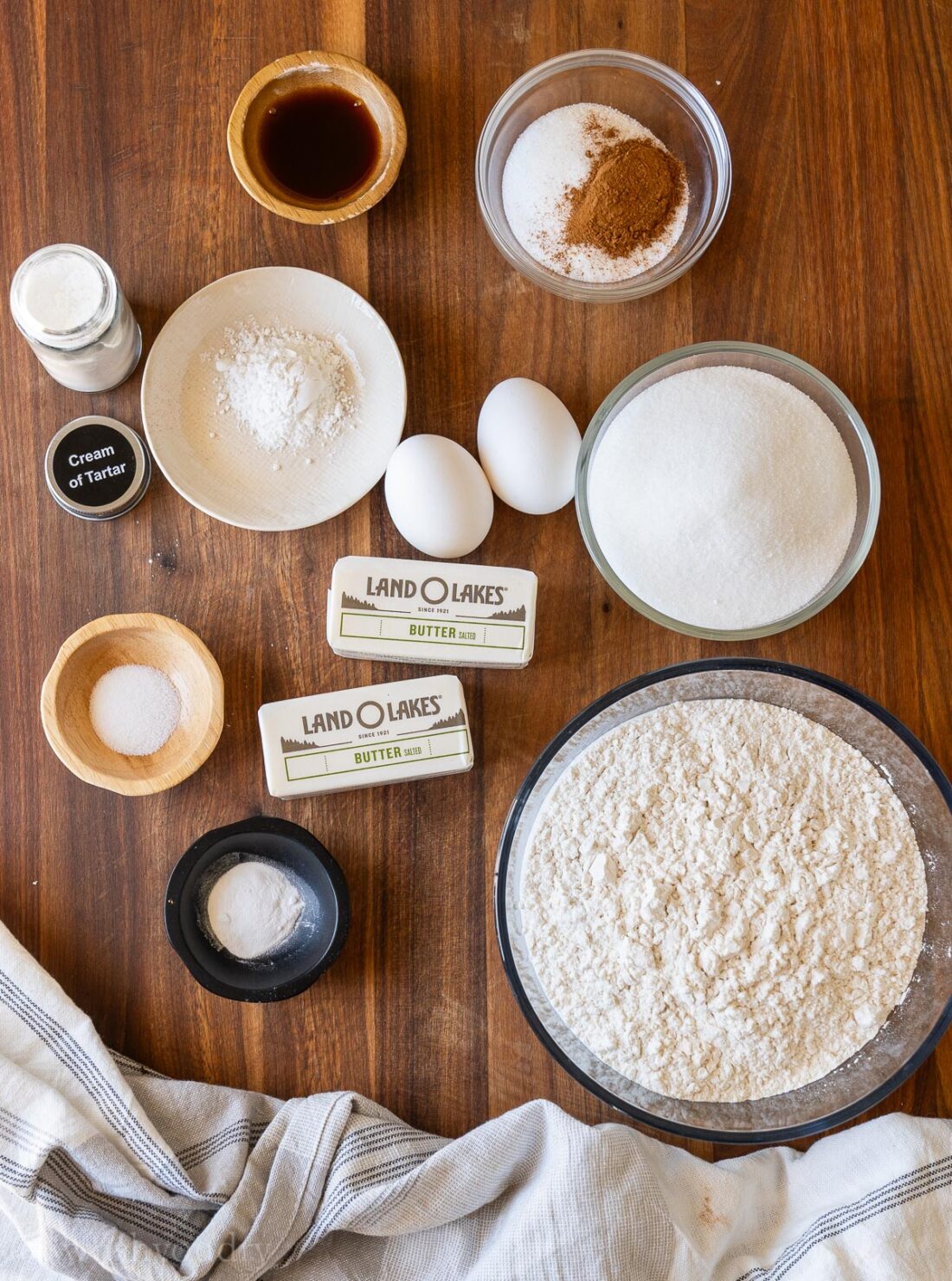 Ingredients for cookies on wooden surface with cream of tartar.