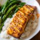 spicy salmon on top of white rice with a side of green beans.