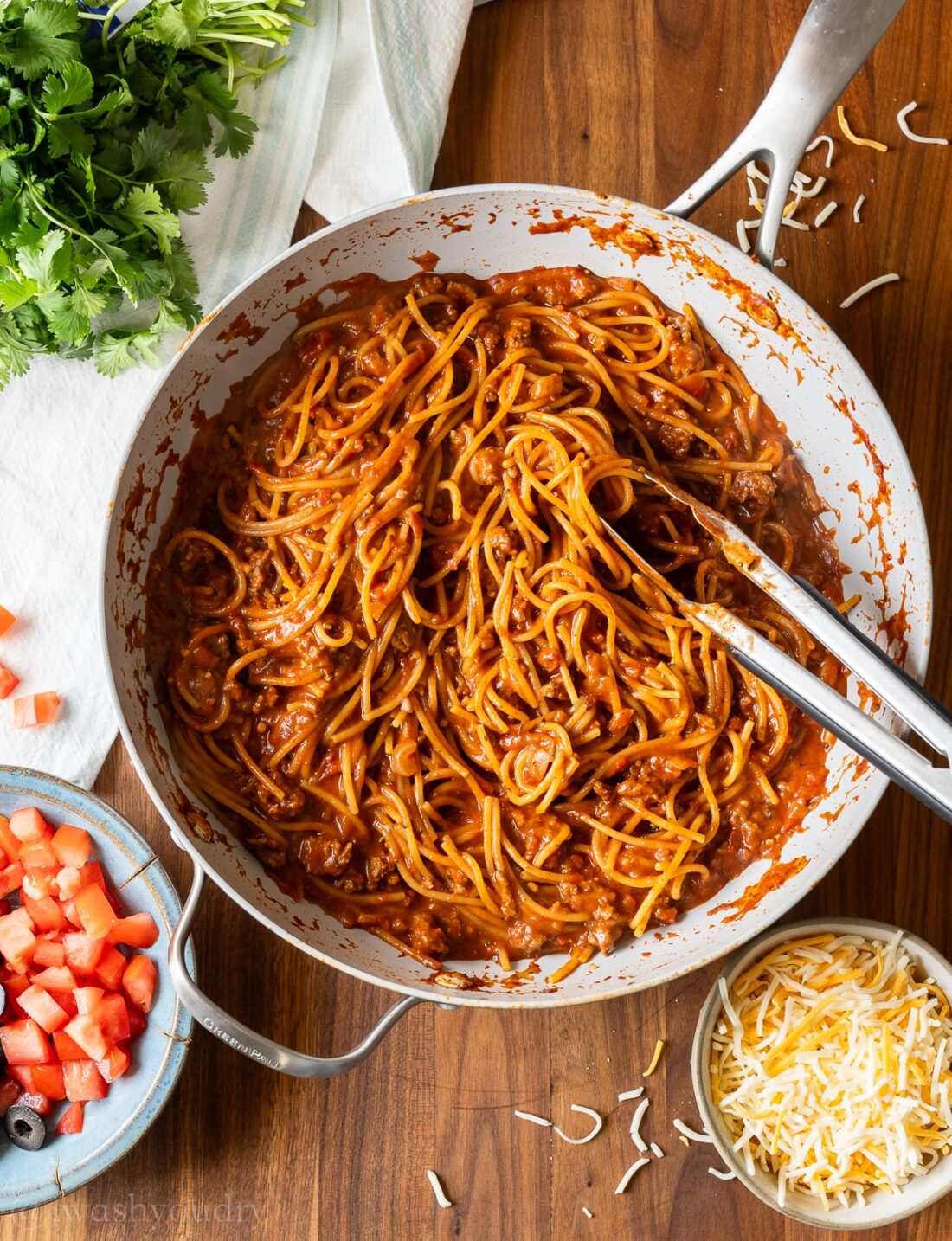 cooked noodles in taco sauce with cheese on the side.